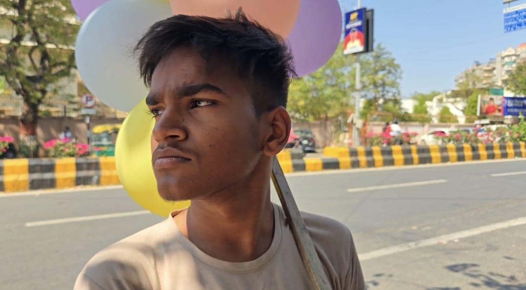 A close portrait of the balloon seller in Kshitij.