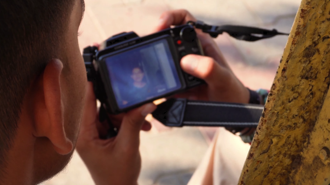 A close view of the photographer looking through his camera in Kshitij.