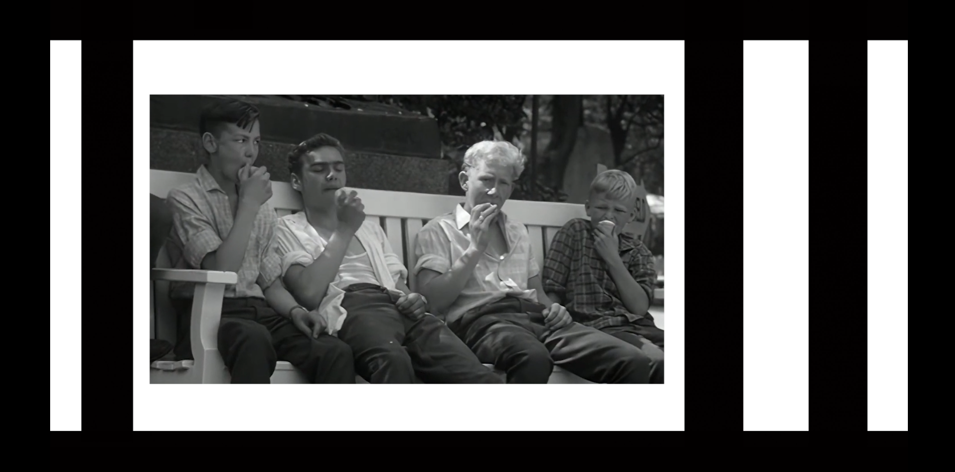 Visitors seated together in a black-and-white frame from the Zoo title sequence.